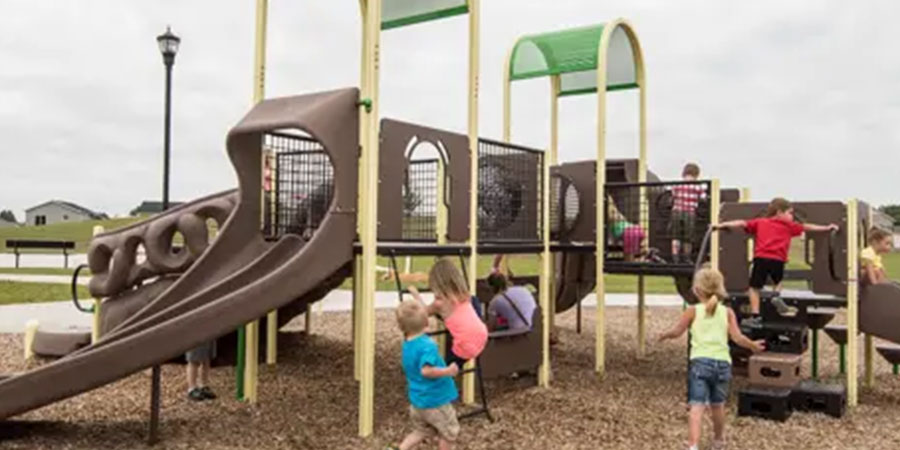 Young Children Climbing Up Arched Playground Structures